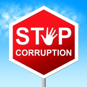A red road sign reading Stop Corruption with a raised hand symbol